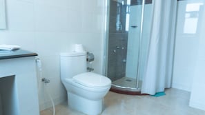 Un baño moderno con inodoro, cabina de ducha y lavamanos.