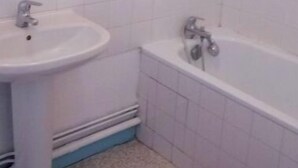A bathroom with a sink, a bathtub, and a mirror.