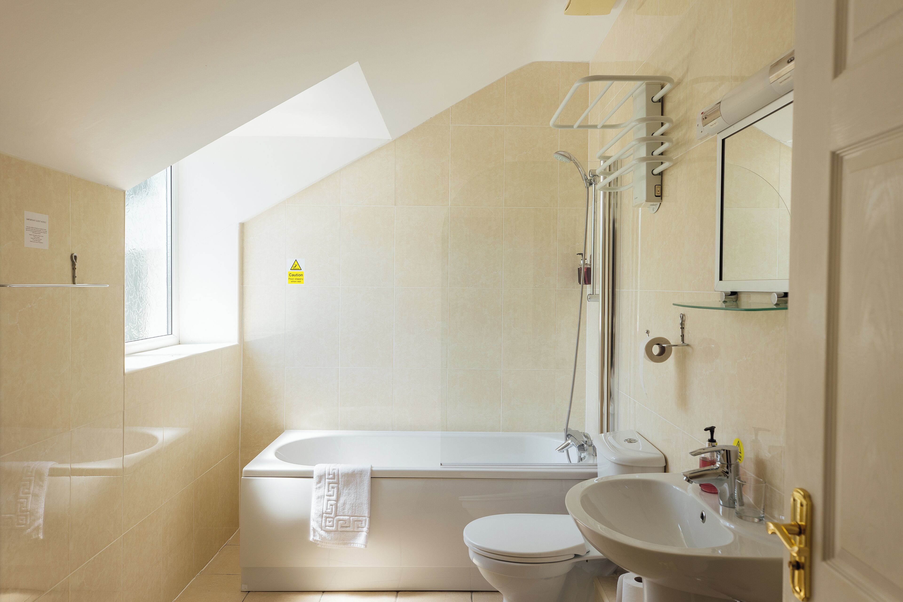 A modern bathroom with a bathtub, toilet, and sink.