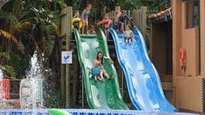 Een waterpark met twee glijbanen en een zwembadgedeelte.