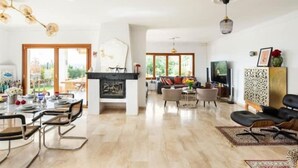 A spacious living area with a fireplace, dining table, and comfortable seating. - Villa Zebra with sea views from every room! (Benalmádena)