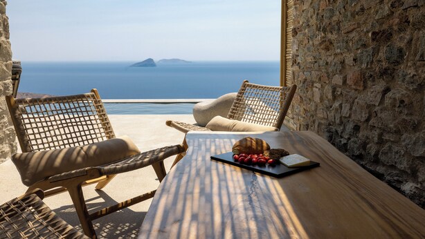 A table with wicker chairs and a view of the sea. - Kalma Living - Luxury Villas (Kithnos)