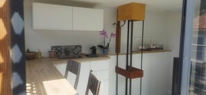Een moderne keuken met een houten aanrecht, witte kastjes, een klein spoelbakje en een potorkidee.