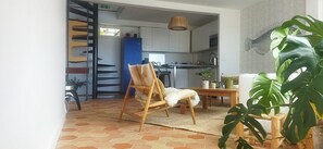 Een moderne woonkamer met een houten stoel, een kleine tafel en een grote plant.
