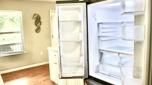 Ein offener Kühlschrank mit mehreren Einlegeböden und einem Gefrierfach.
