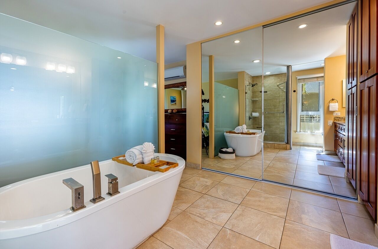 A modern bathroom with a large bathtub, a glass shower enclosure, and a visible shower area.