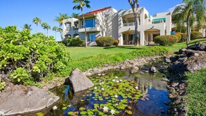 A resort with a pool surrounded by rocks and lily pads, palm trees, and a well-maintained lawn. - Palms at Wailea Two Bedrooms - Partial Ocean View by Coldwell Banker Island Vacations (Kihei)