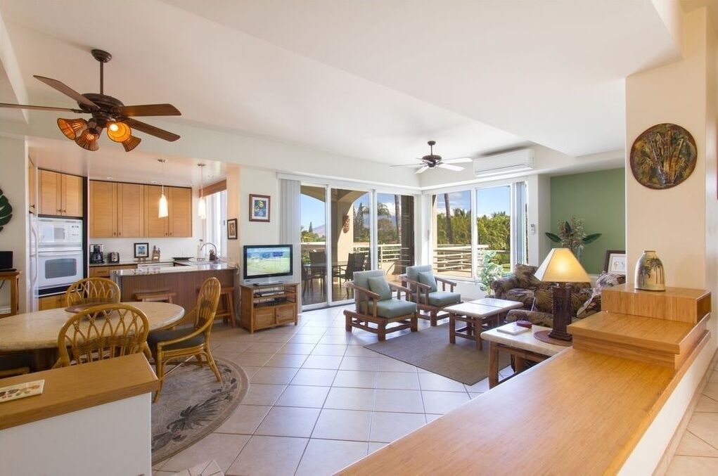 A spacious living area with a kitchen, dining area, and a balcony with a view.
