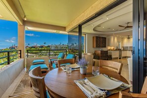 Un comedor con vistas al océano y un balcón con mobiliario exterior.