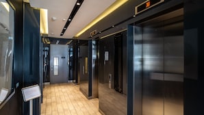 A modern elevator area with a digital display showing '38', a no-smoking sign, and a sign indicating the elevator is out of service. - Luxury 2-bed Croydon Apartment Near Gatwick (Croydon)