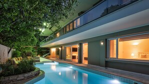Una casa moderna con piscina, ventanas amplias y un interior muy iluminado.