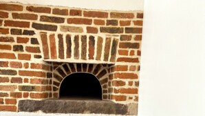 Ein Backofen mit roter Feuersteinbasis und weißer Wand.