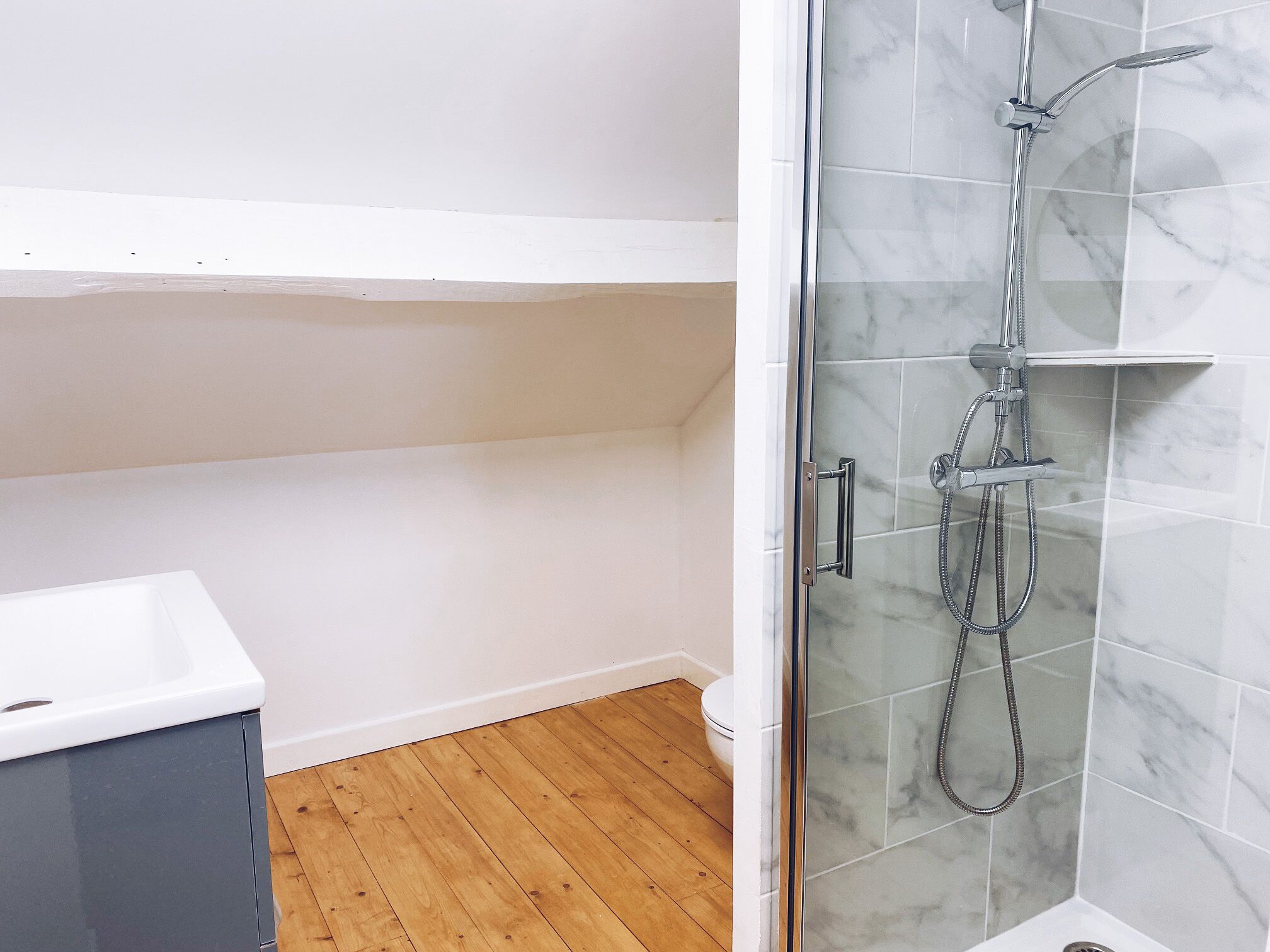 Ein Badezimmer mit Dusche, Toilette und Waschbecken.