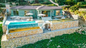 A two-story house with a swimming pool, stone walls, and a patio area. - Villa Ieros - Three Bedroom Villa, Sleeps 6 (Ionian Islands)