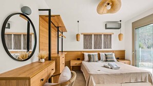 A modern bedroom with a wooden dresser, a large bed with multiple pillows, a round mirror, and a hanging light fixture. - Villa Ieros - Three Bedroom Villa, Sleeps 6 (Ionian Islands)