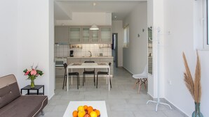 A modern apartment with a living room, dining area, and kitchen. - Glaros Homes (Chania)