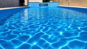 Ein Schwimmbecken mit klarem, blauem Wasser und einer gefliesten Kante.