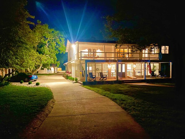 A two-story house with a covered porch and a visible garage. - Beach Club: your own private "Caribbean" resort (Piney Point)