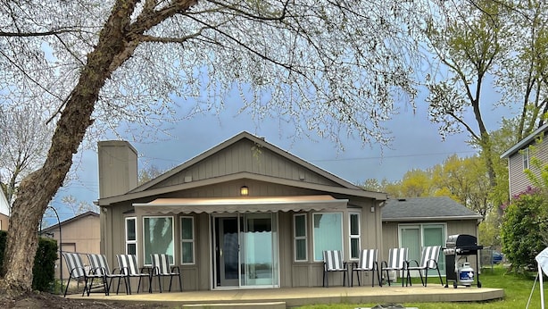 A two-story house with a covered patio and outdoor seating area.