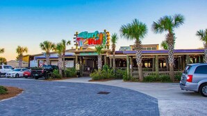 A building with a colorful sign reading "Surf Hut." - Sunsets You'll Never Forget- Private Patio/Hot Tub/Heated Pool (Miramar Beach)