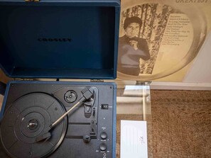 An open Crosley record player with a visible turntable and control knobs, placed inside a blue case. - Authentic Restored Apt In The Old City (Tel Aviv-Yafo)