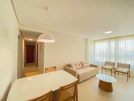 Una sala de estar moderna con una mesa de comedor, sofá y sillas.
