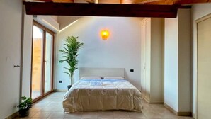 A bedroom with a bed, a potted plant, and a wall-mounted light fixture. - ⭑ ⭑ ⭑ ⭑ Elegant apartment with whirlpool and gymnasium (Silvi)