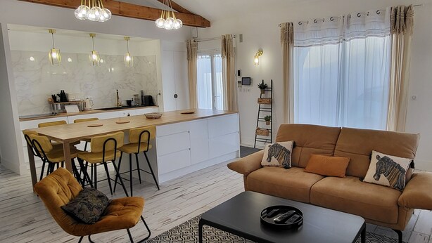 Uma sala de estar moderna com sofá, mesa de centro e área de jantar.