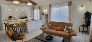Una sala de estar moderna con un sofá, una mesa de centro y una zona de comedor.