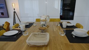 A dining table set with plates, cutlery, glasses, and a centerpiece labeled "Pain & Tartines".