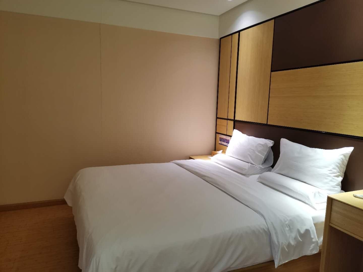 Ein Hotelzimmer mit einem Bett, einem Nachttisch und einem hölzernen Kopfteil.