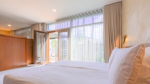 A hotel room with a large bed, a wardrobe, and a sliding glass door leading to a balcony. - Rixwell Collection Seaside Hotel Jurmala (Jurmala)