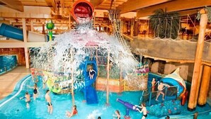 An indoor water park with multiple water play areas, slides, and a central water feature. - Rixwell Collection Seaside Hotel Jurmala (Jurmala)