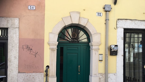 A green door with a stone archway, a mailbox, and a number 52 sign on a yellow wall. - VERONETTA 52 (Verona)