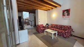 A living room with a sofa, coffee table, and a poster on the wall. - VERONETTA 52 (Verona)