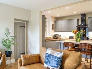 Eine moderne Küche mit Einbauofen, Mikrowelle und einem großen Fenster über der Arbeitsplatte.