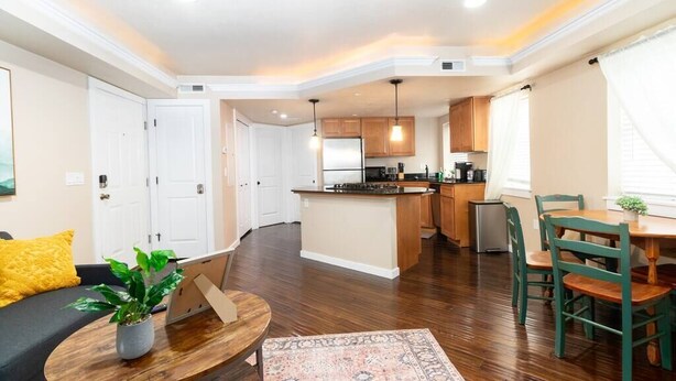 A modern apartment with a kitchen, dining area, and living room.