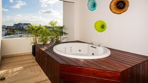 Ein modernes Badezimmer mit einer Holzwanne, einer Topfpflanze und dekorativen Glasplatten an der Wand.