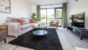 A modern living room with a sofa, coffee table, and TV.