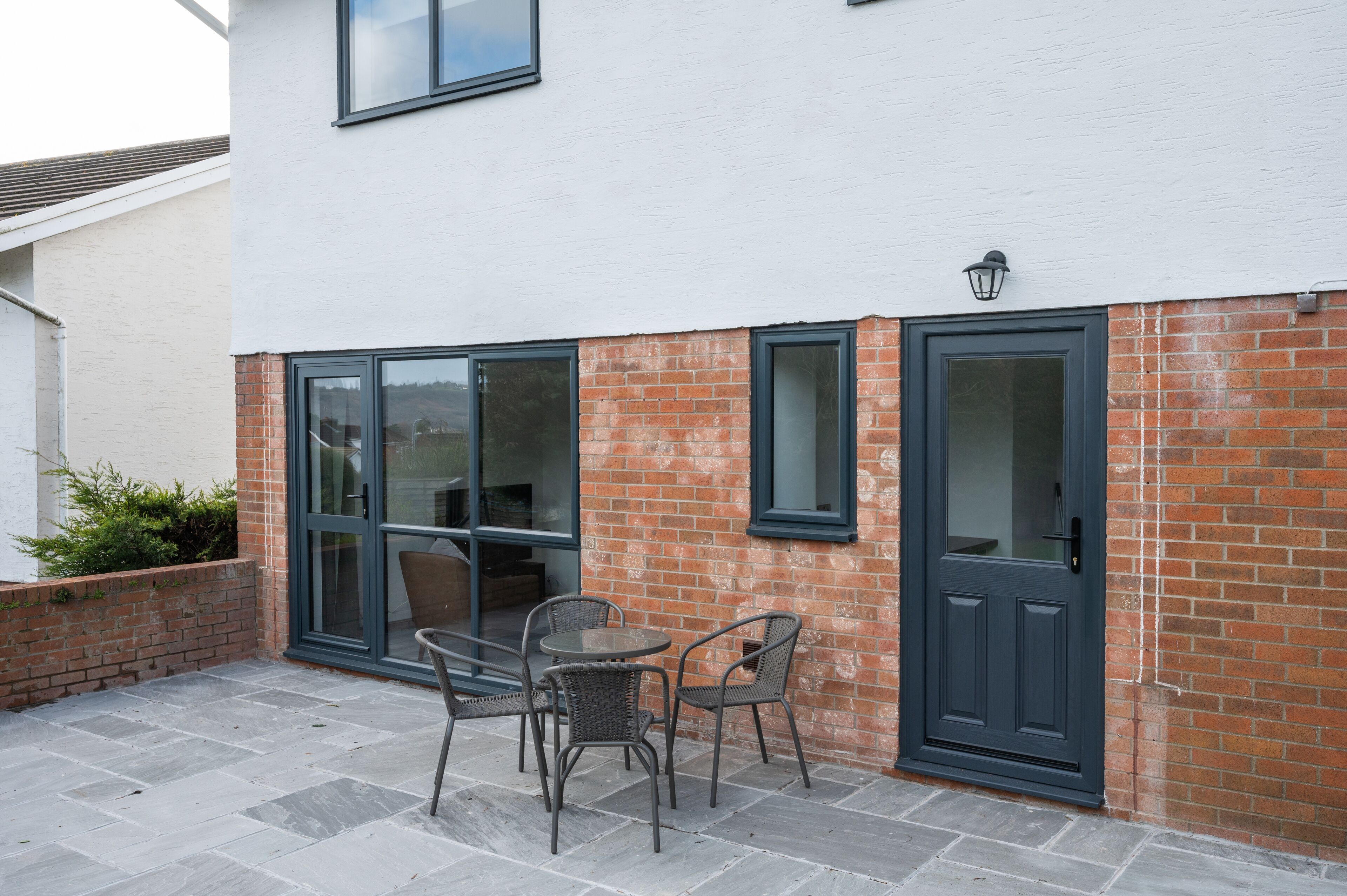 A patio area with a table and chairs, a door, and a window.