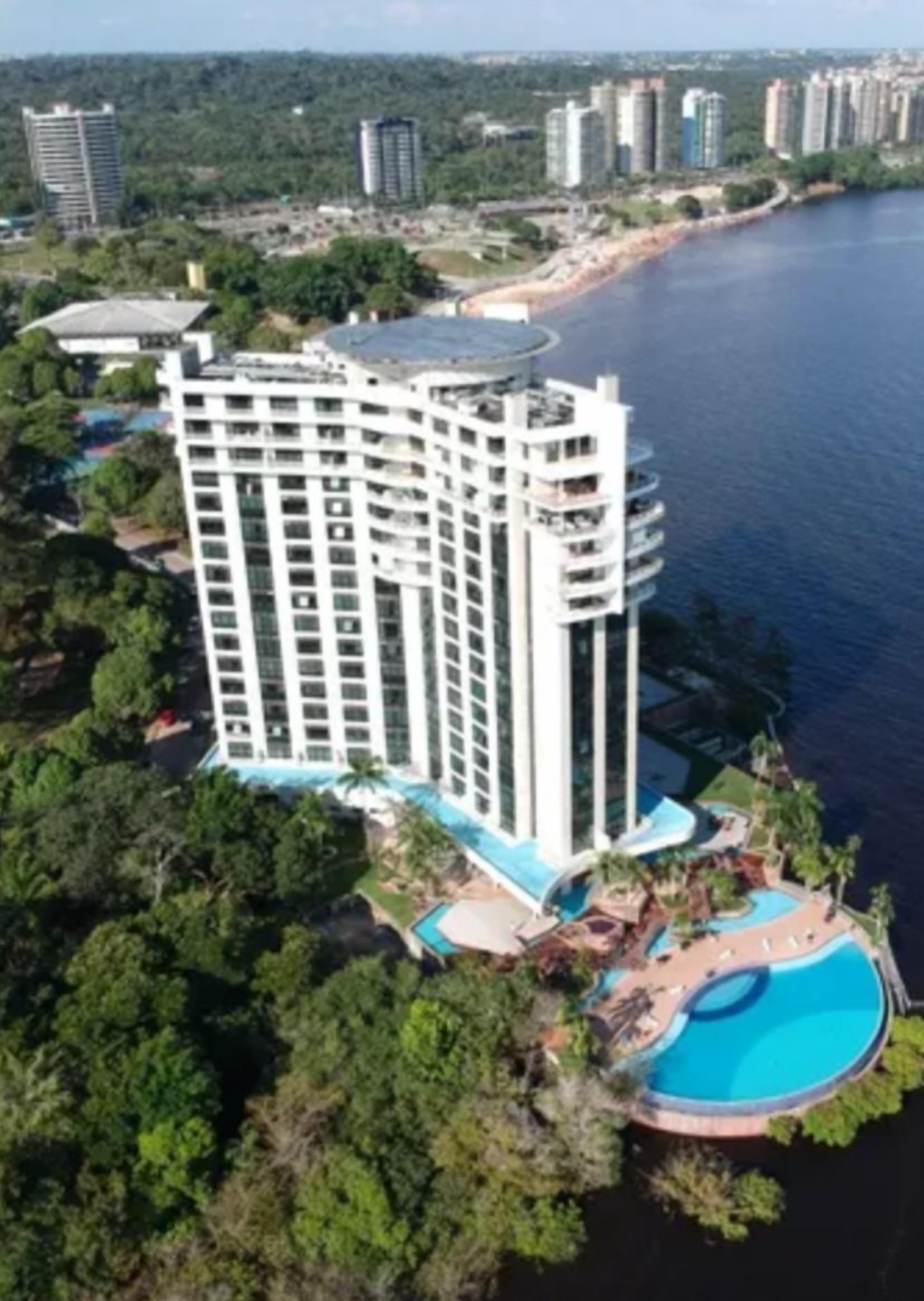 A high-rise hotel with a pool and a beachside view.