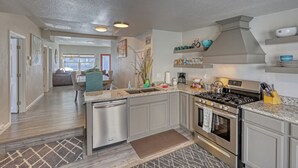 Una cocina moderna con encimeras de granito, electrodomésticos de acero inoxidable y una isla central.