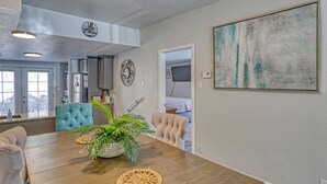 Un comedor con una mesa de madera, sillas tapizadas en azul y una planta en maceta.