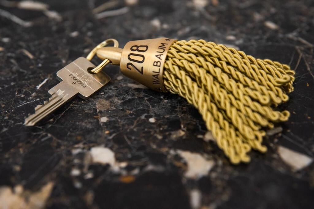 A key with a golden tassel and the number 208 on it.