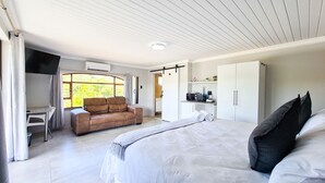 A bedroom with a bed, a sofa, a desk, and a wardrobe. - Vincent Valley Lodge (East London)
