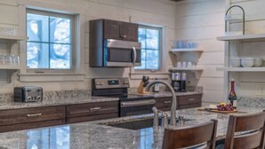 Una cucina moderna con piani in granito, elettrodomestici in acciaio inossidabile e mobili in legno.