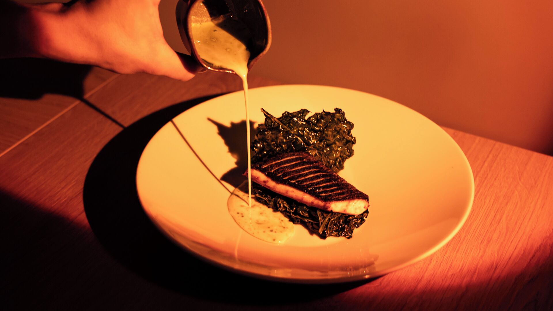 Un piatto con una bistecca e verdure condite con salsa.