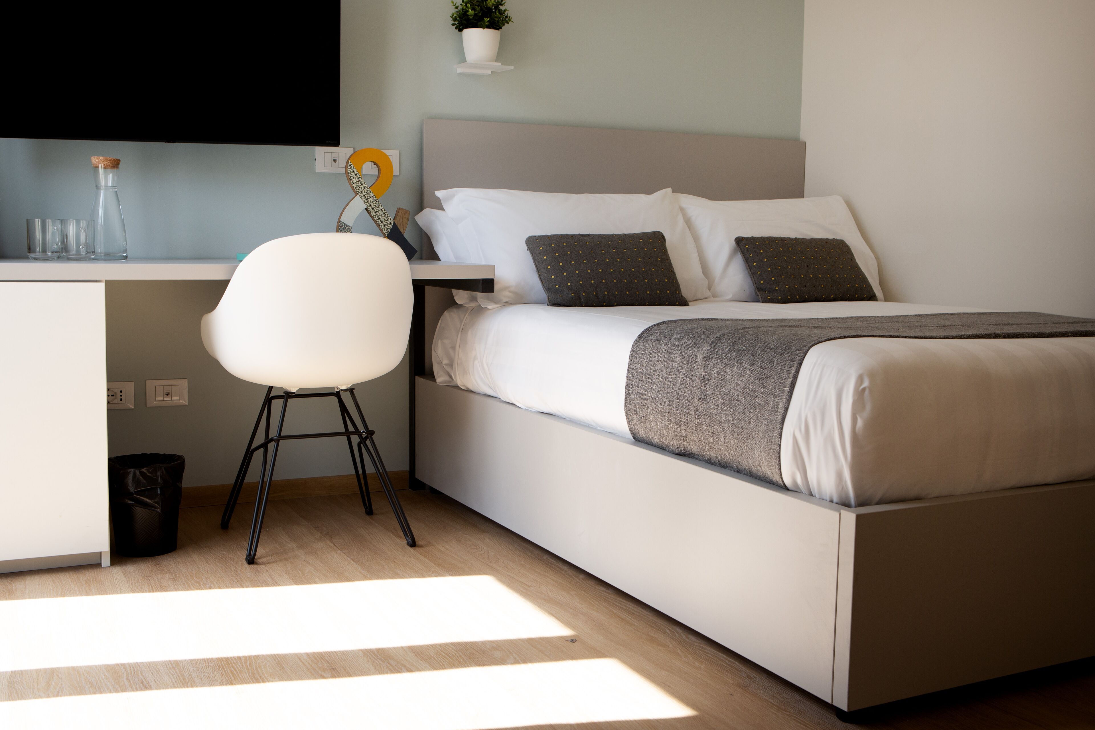 Une chambre à coucher moderne avec un lit, un bureau et une chaise.