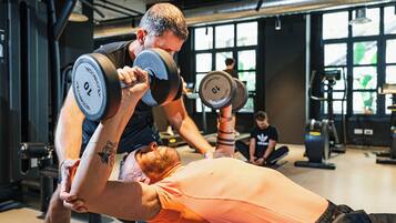Une salle de sport où une personne effectue un exercice de développé couché.