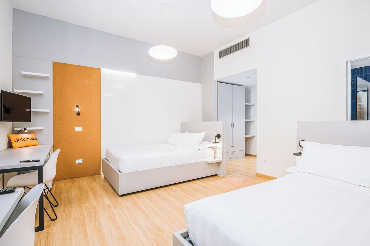Une chambre d’hôtel moderne équipée d’un lit, d’un bureau et d’une armoire.